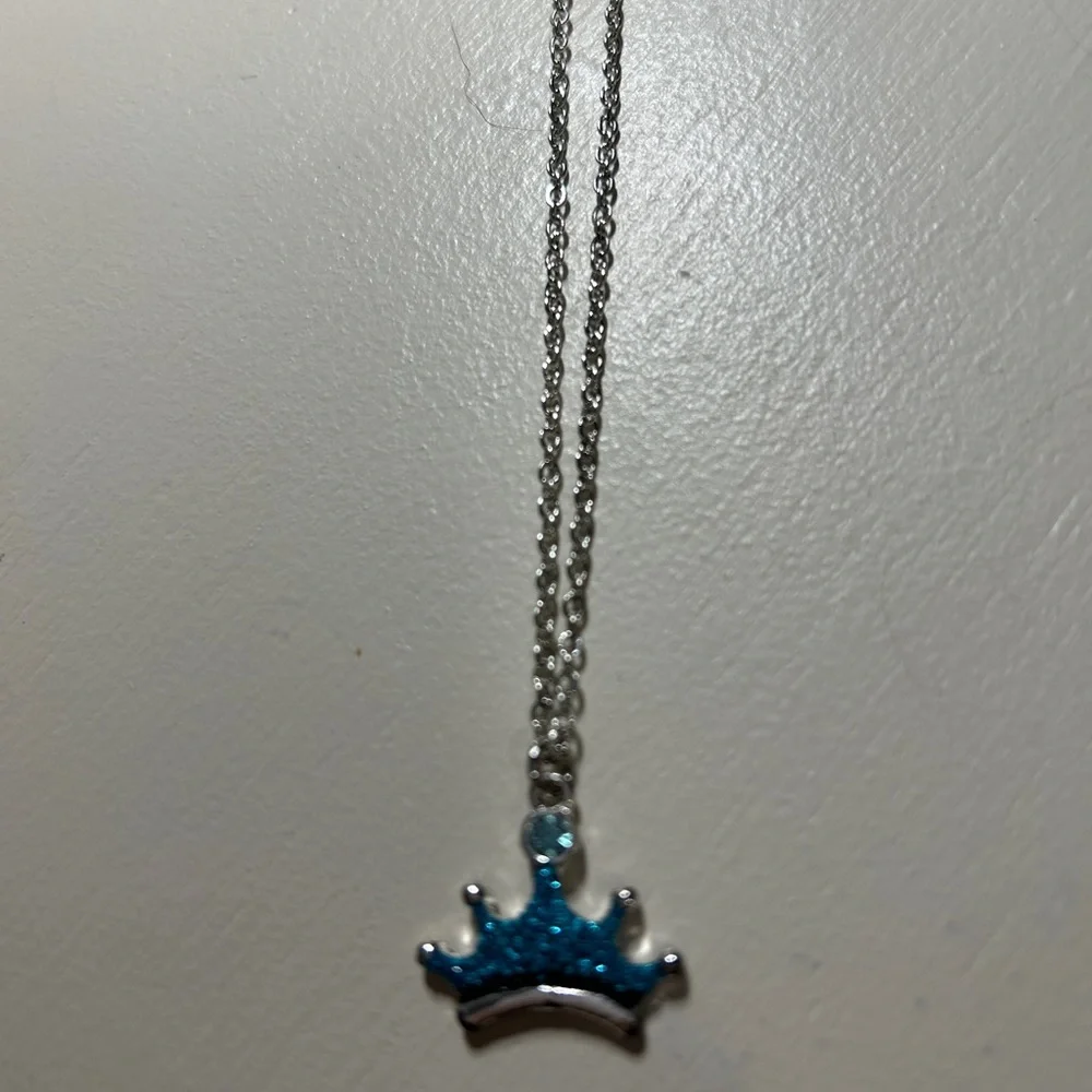 Girls 14” silver necklace w/3” extender. Has a blue crown pendant. Gently used.